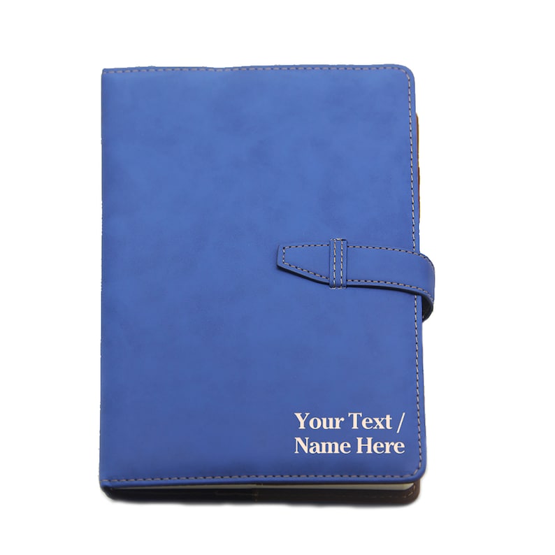 May include: A blue leather-bound journal with a strap closure and the text "Your Text / Name Here" embossed on the front cover.