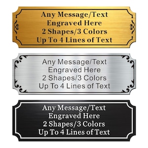 May include: Three rectangular engraved signs in gold, silver, and black. Each sign has decorative corner accents and the text "Any Message/Text Engraved Here, 2 Shapes/3 Colors, Up To 4 Lines of Text."