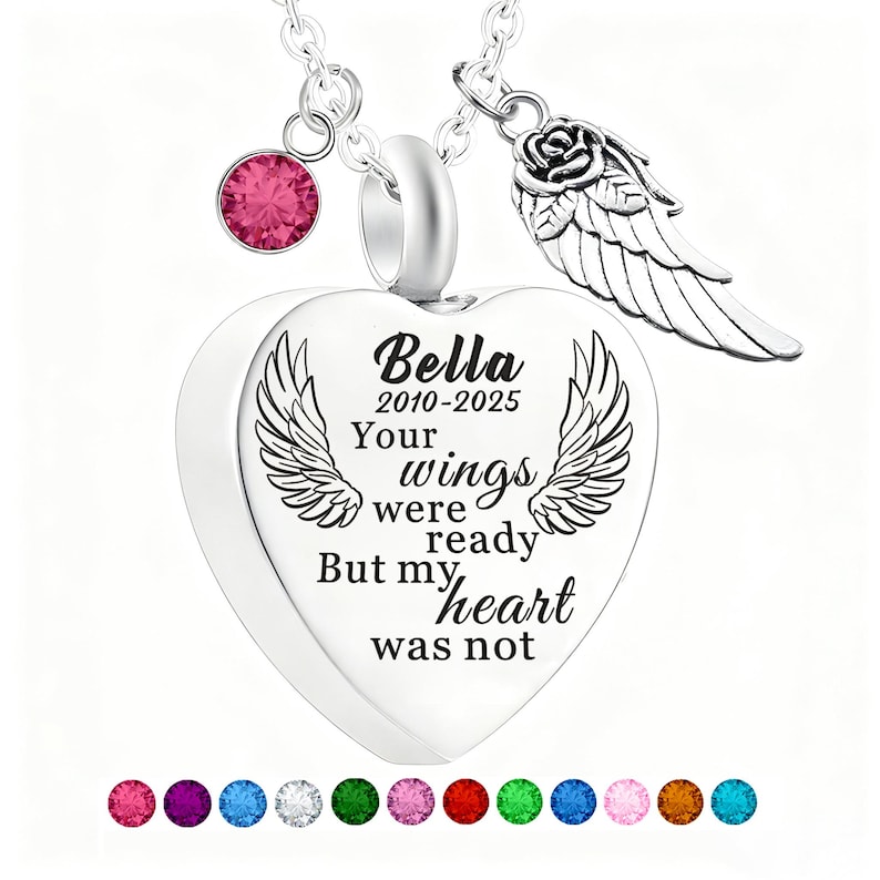 May include: A silver heart-shaped pendant necklace with the inscription "Bella 2010-2025 Your wings were ready But my heart was not." The necklace includes a pink gemstone, a rose and wing charm, and a selection of colorful gemstones.
