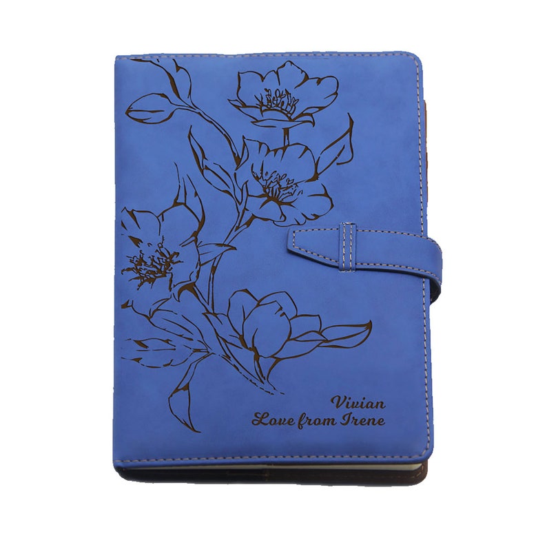 Peut inclure: Un carnet en cuir bleu avec un motif floral et le texte "Vivian Love from Irene" grav&eacute; sur la couverture.