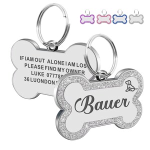 May include: Silver bone-shaped dog tag with a sparkly border. The tag has the text "IF I AM OUT ALONE I AM LOST PLEASE FIND MY OWNER LUKE 077785 36 LUONDON" on one side and the name "Bauer" on the other side. The tag comes with a silver ring.