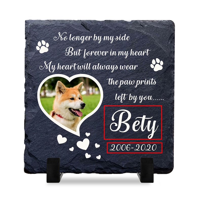 Puede incluir: Una placa conmemorativa de pizarra negra con una foto de un perro en forma de coraz&oacute;n. La placa dice "No longer by my side But forever in my heart My heart will always wear the paw prints left by you...... Bety 2006-2020".