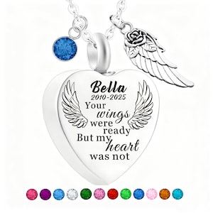 May include: A silver heart-shaped pendant necklace with the inscription "Bella 2010-2025 Your wings were ready But my heart was not." The necklace features a blue gemstone, a rose and wing charm, and a selection of colorful gemstones.