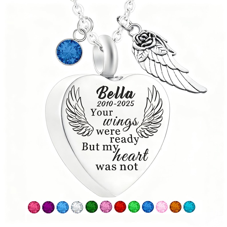 May include: A silver heart-shaped pendant necklace with the inscription "Bella 2010-2025 Your wings were ready But my heart was not." The necklace features a blue gemstone, a rose and wing charm, and a selection of colorful gemstones.