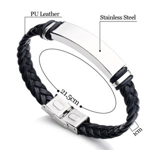 Op de afbeelding: Zwart gevlochten lederen armband met een plaat van roestvrij staal en een zilveren sluiting. Het armband is 21,5 cm lang en 1 cm breed.