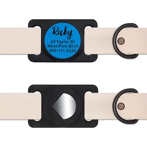 May include: A black and white dog collar with a blue and white tag that says "Ruby" with an address and phone number. The tag is attached to the collar with a black plastic clip.