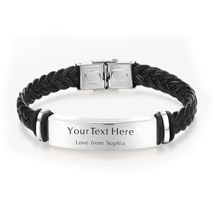 Op de afbeelding: Zwart leren armband met een gevlochten ontwerp en een zilveren metalen sluiting. De armband heeft een zilveren metalen plaat met de tekst "Your Text Here Love from Sophia".