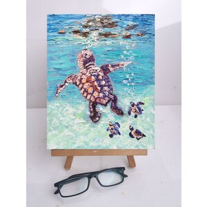 May include: A painting of a sea turtle and her babies swimming in the ocean. The mother turtle is brown and has a light blue background. The baby turtles are smaller and have a darker blue background.