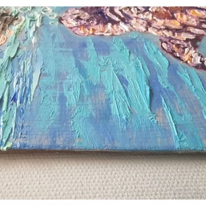 May include: A close-up of a textured blue and green abstract painting with thick brushstrokes. The painting is on a wooden canvas.