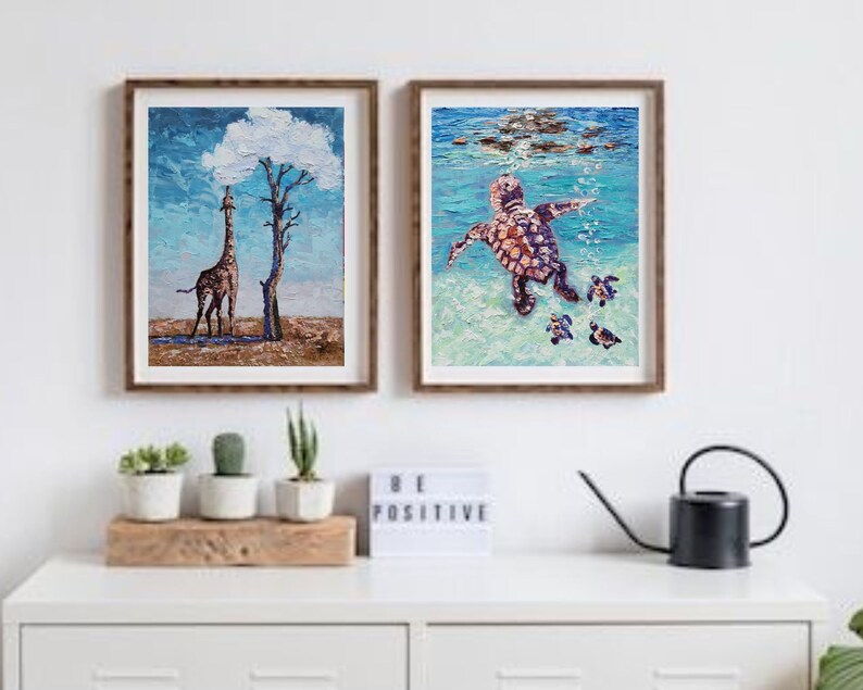 May include: Two framed paintings, one depicting a giraffe standing under a cloud shaped like a tree, the other showing a sea turtle swimming with smaller turtles. Both paintings are done in a textured style.