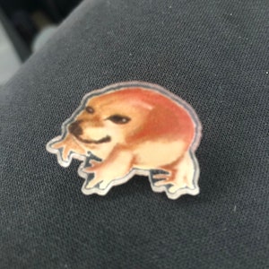 May include: A clear plastic sticker with a cartoon image of a brown dog with a surprised expression.