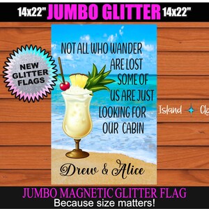 Puede incluir: Una bandera de purpurina jumbo de 35,56 x 55,88 cm con una escena de playa y una bebida tropical. El texto en la bandera dice "Not all who wander are lost, some of us are just looking for our cabin." La bandera tambi&eacute;n tiene el texto "Drew & Alice" y "Island Clout" en ella.
