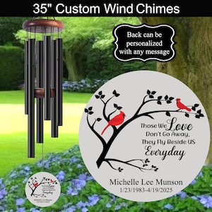 May include: 35 inch custom wind chime with a black metal frame and red cardinal birds on a white background. The chime features the text "Those We Love Don't Go Away, They Fly Beside Us Everyday" and a personalized message with a name and dates.