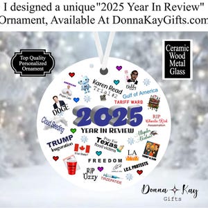 May include: A white ceramic ornament with the text "2025 Year In Review" and various graphics and text elements. Includes the text "Donna Kay Gifts". The ornament has a white ribbon for hanging.