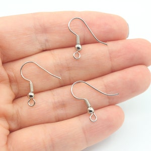 May include: Three silver earring hooks with a small ball at the end of each hook.