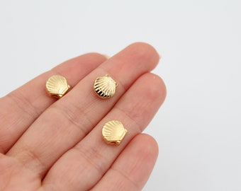 May include: Three gold-colored seashell charms. The charms are small and have a detailed design.