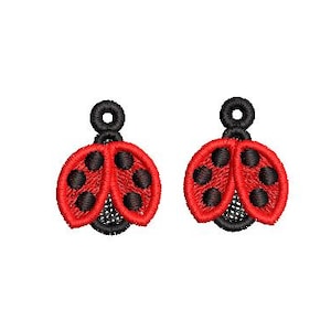 May include: Pair of embroidered ladybug earrings. Each earring features a red wing design with black spots, a black head, and a small black loop at the top for hanging. The earrings are set against a white background.