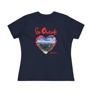 May include: A navy blue women's t-shirt with a red heart graphic. The heart graphic contains a photo of a mountain lake and the text "Go Outside".
