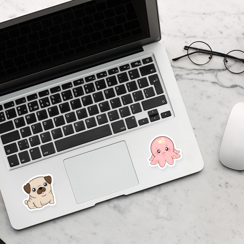 May include: A white laptop computer with a black keyboard and a touchpad. There are two stickers on the laptop, one of a cartoon pug and one of a cartoon octopus.
