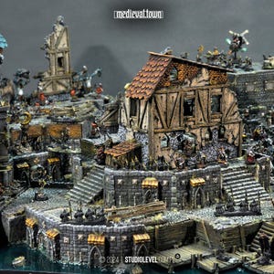 May include: A detailed miniature diorama of a medieval town featuring weathered timber-framed buildings, stone walls, and docks. The scene includes small figurines, a statue, and the text medieval.town and 2024 STUDIOLEVEL.COM visible.