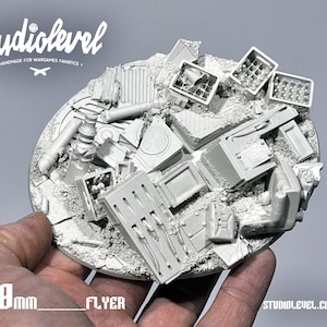Puede incluir: Una base redonda de resina gris de 120 mm de diámetro para wargaming de miniaturas. La base está cubierta de diversos escombros, incluyendo tuberías, cajas y otros escombros. El texto "120mm_FLYER" está impreso en la base.
