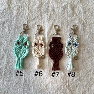 May include: Four macrame owl keychains in shades of teal, cream, brown, and white, each with a silver clasp. The owls have button eyes and a tassel at the bottom. Each keychain is labeled with a number from #5 to #8.