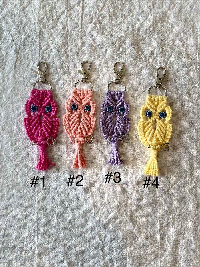 May include: Four macrame owl keychains in shades of pink, peach, purple, and yellow. Each owl has blue eye beads and a tassel. The keychains are labeled #1, #2, #3, and #4.