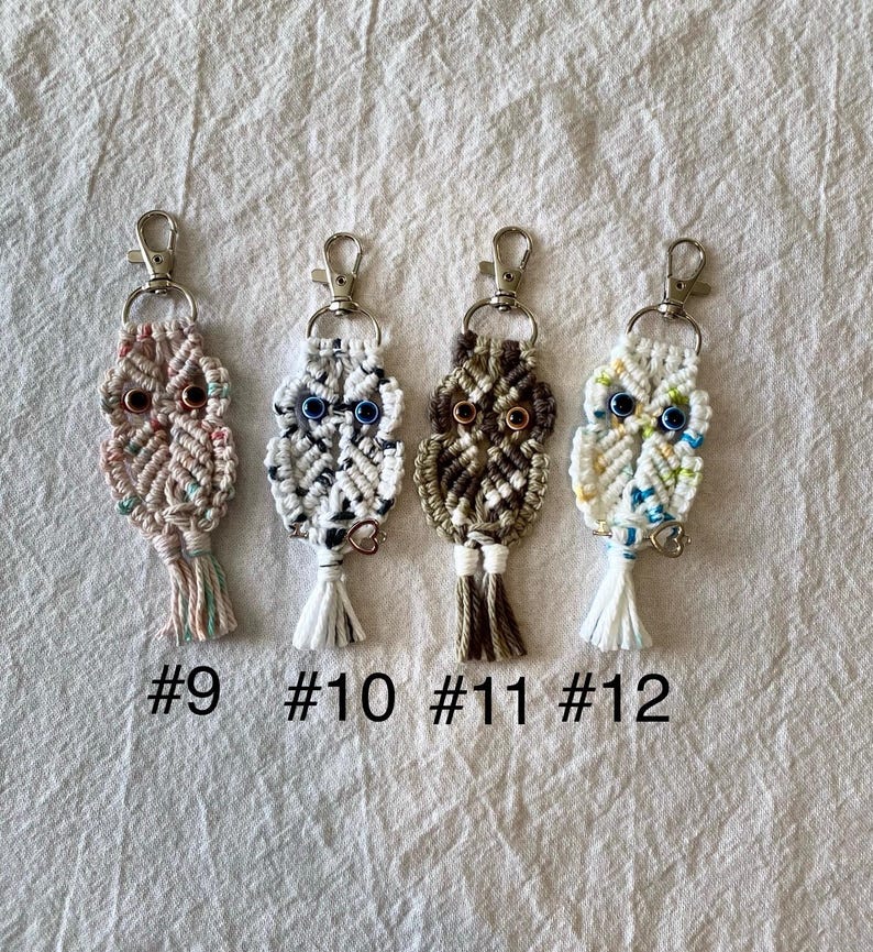 May include: Four handmade macrame owl keychains with metal clasps. Each owl has a unique color scheme, including pink, white, brown, and cream. The keychains are labeled with the numbers #9, #10, #11, and #12.