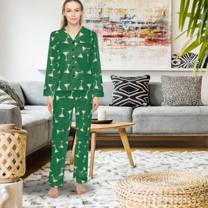 May include: Green pajama set with a martini glass pattern. The long-sleeved top has a button-down front and the pants have a relaxed fit. The pajamas are made of a soft fabric and are suitable for lounging.