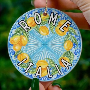 Könnte beinhalten: Runder Keramik-Anhänger mit blau-weißem Design mit Zitronen und den Worten "ROME ITALIA".