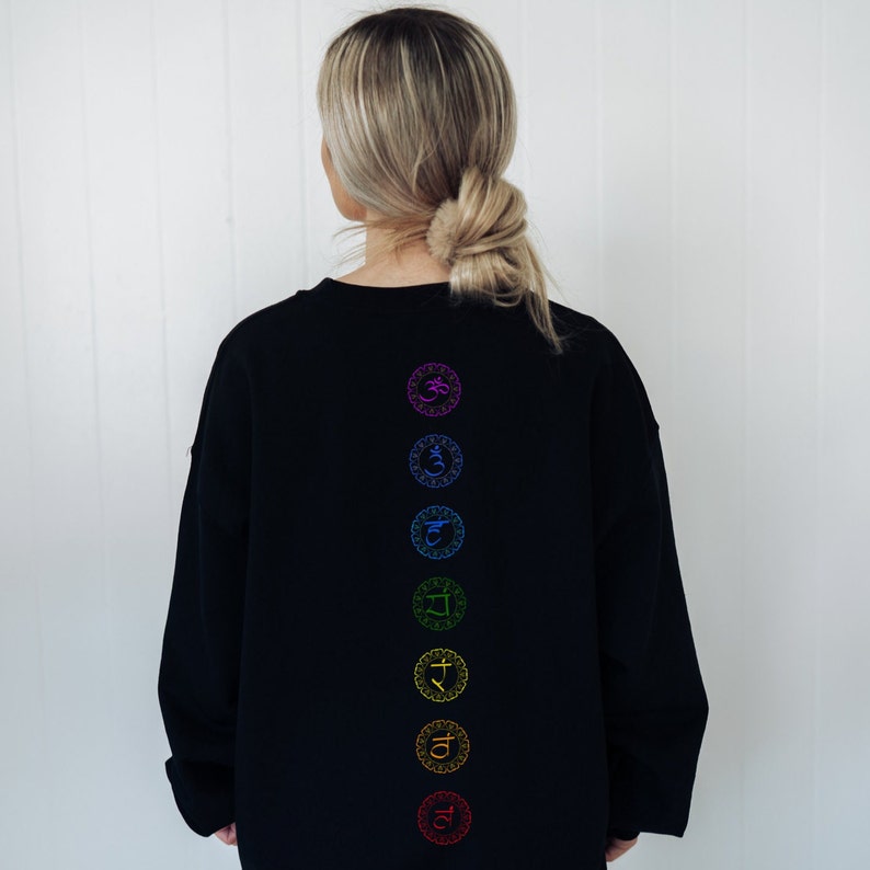 May include: Black sweatshirt with a vertical row of seven colorful chakra symbols on the back.