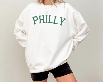 May include: White sweatshirt with a green "PHILLY" graphic on the front.