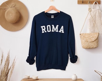May include: A navy blue sweatshirt with white lettering that reads "ROMA" on the front.