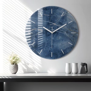 May include: A round blue and white marble patterned wall clock with white hands and a gold centre.