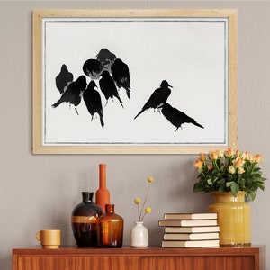 May include: A framed black and white print of a flock of birds in flight. The birds are silhouetted against a white background. The frame is made of light wood.