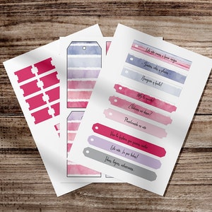 Peut inclure: Feuilles de papier avec des motifs aquarelles et du texte. Les motifs comprennent des étiquettes et des étiquettes aquarelles roses et bleues avec des phrases en espagnol. Le papier est sur une surface en bois.