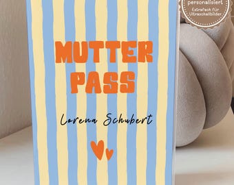 May include: A rectangular protective cover for a maternity record book featuring vertical light blue and pale yellow stripes. The text MUTTER PASS is printed in orange, followed by the name Lorena Schubert and two orange heart icons.