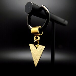 Peut inclure: Boucle d'oreille triangle en or avec une finition brossée, suspendue à une boucle d'oreille en forme de cercle avec une perle dorée.