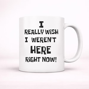 Puede incluir: Taza de cerámica blanca con asa curvada. La taza presenta el texto negro: "I REALLY WISH I WEREN'T HERE RIGHT NOW!" La taza está diseñada para bebidas calientes y es adecuada para uso doméstico o de oficina.