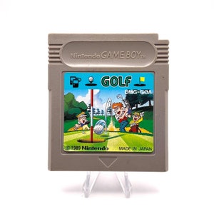 K&ouml;nnte beinhalten: Eine graue Game Boy-Cartridge mit einem bunten Etikett, das eine Golfszene zeigt. Das Etikett tr&auml;gt die Aufschrift "GOLF" und "DMG-GOA". Der Text "&copy; 1989 Nintendo MADE IN JAPAN" ist ebenfalls auf dem Etikett zu sehen.