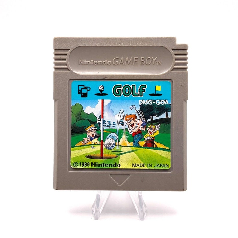 K&ouml;nnte beinhalten: Eine graue Game Boy-Cartridge mit einem bunten Etikett, das eine Golfszene zeigt. Das Etikett tr&auml;gt die Aufschrift "GOLF" und "DMG-GOA". Der Text "&copy; 1989 Nintendo MADE IN JAPAN" ist ebenfalls auf dem Etikett zu sehen.