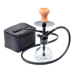 May include: A black hookah with a clear glass base, a black metal stem, and a terracotta-colored bowl. A black carrying case is on the left. The hookah has a flexible black hose with a silver coil.