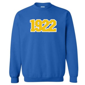 May include: Royal blue sweatshirt with a gold yellow 1922 printed on the front.