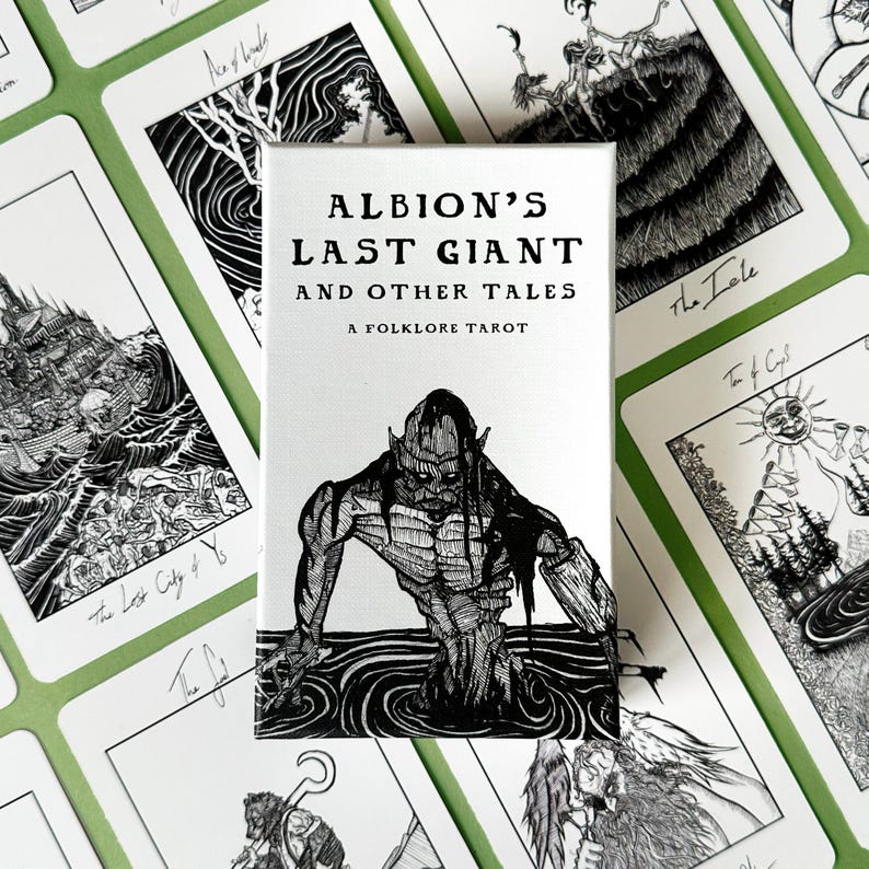 K&ouml;nnte beinhalten: Ein Tarotkartenspiel mit dem Titel "Albion's Last Giant and Other Tales: A Folklore Tarot". Die Schachtel zeigt eine Schwarz-Wei&szlig;-Illustration einer Kreatur im Wasser. Weitere Karten mit Schwarz-Wei&szlig;-Illustrationen sind sichtbar.
