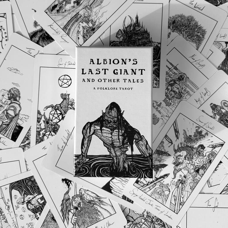 K&ouml;nnte beinhalten: Schwarz-Wei&szlig;-Bild eines Tarot-Decks. Das Deck enth&auml;lt eine Box mit dem Text "ALBION'S LAST GIANT AND OTHER TALES A FOLKLORE TAROT" und Illustrationen von Figuren. Die Karten sind um die Box herum verstreut und zeigen verschiedene Zeichnungen.