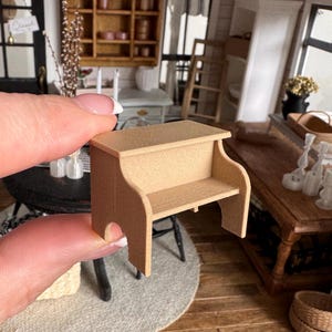 以下が含まれることがあります： ライトブラウン仕上げのミニチュア木製ベンチ。 ベンチは長方形の天板と下の棚があり、側面は湾曲し、アーチ型の開口部があります。 このドールハウスの家具は装飾目的で設計されています。