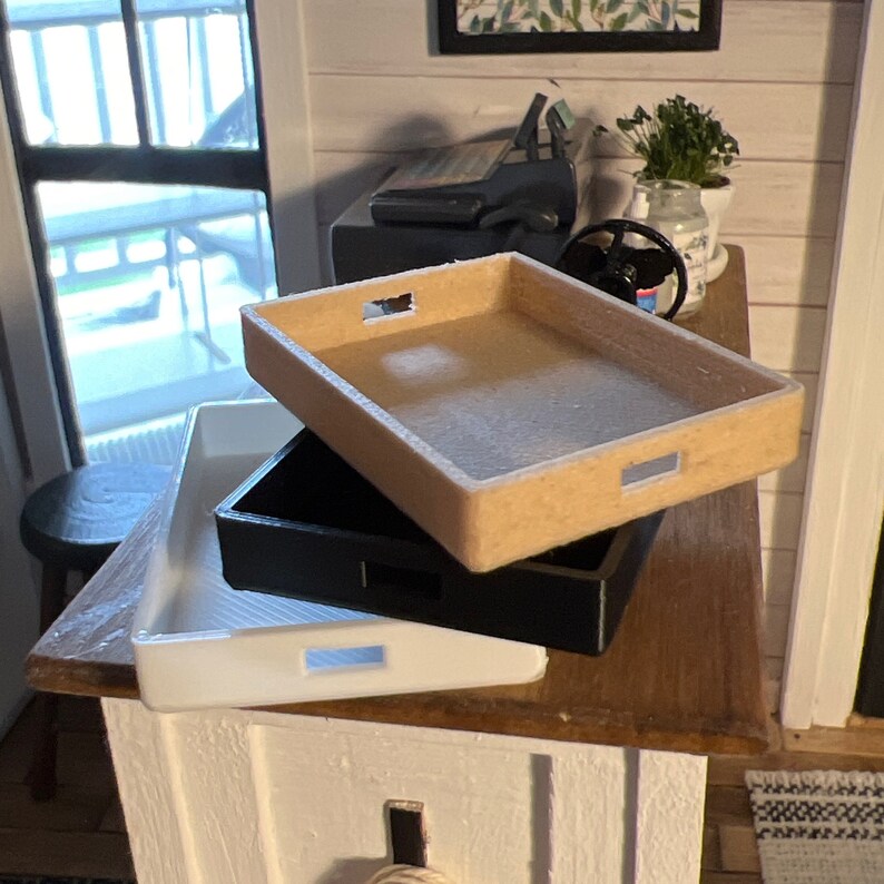 May include: Three rectangular trays stacked on top of each other. The top tray is beige, the middle tray is black, and the bottom tray is white.