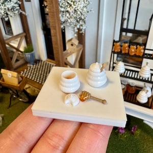 Può includere: Una tazza di ceramica bianca con manico nero e la scritta "But First, Coffee" in nero, in grassetto. La tazza è su una superficie bianca. La tazza è alta 10 cm.