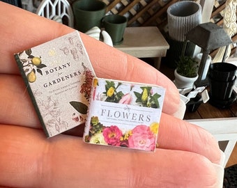 May include: Two miniature books, one titled "Botany for Gardeners" with a floral design and the other titled "Flowers" with a colorful floral illustration.