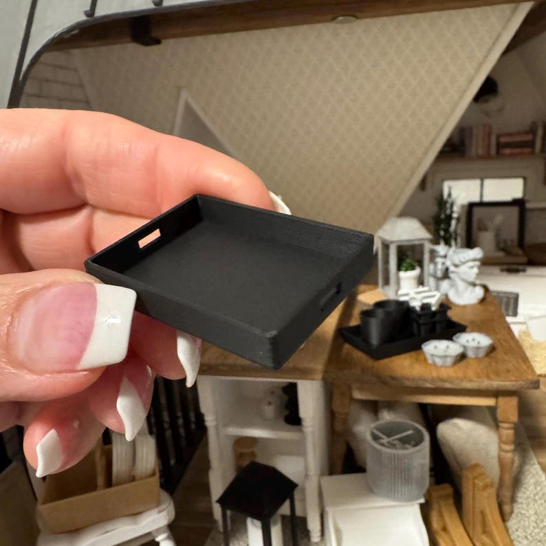 May include: A black miniature tray with a handle. The tray is made of plastic and is about 3 inches long.